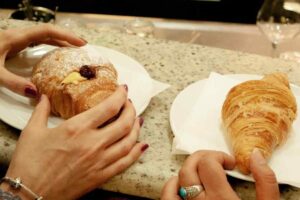 Persone che mangiano croissant al bar