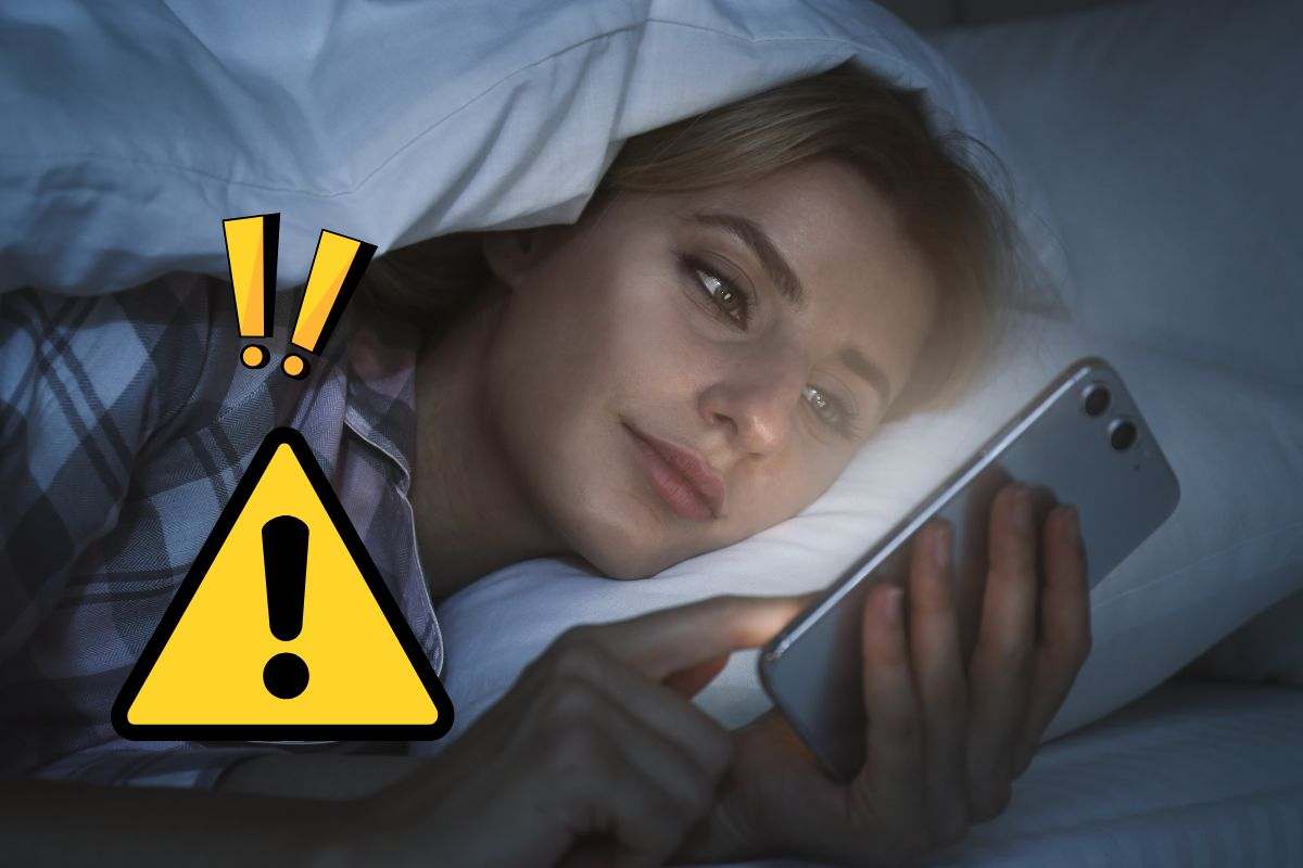 Ragazza guarda smartphone distesa a letto