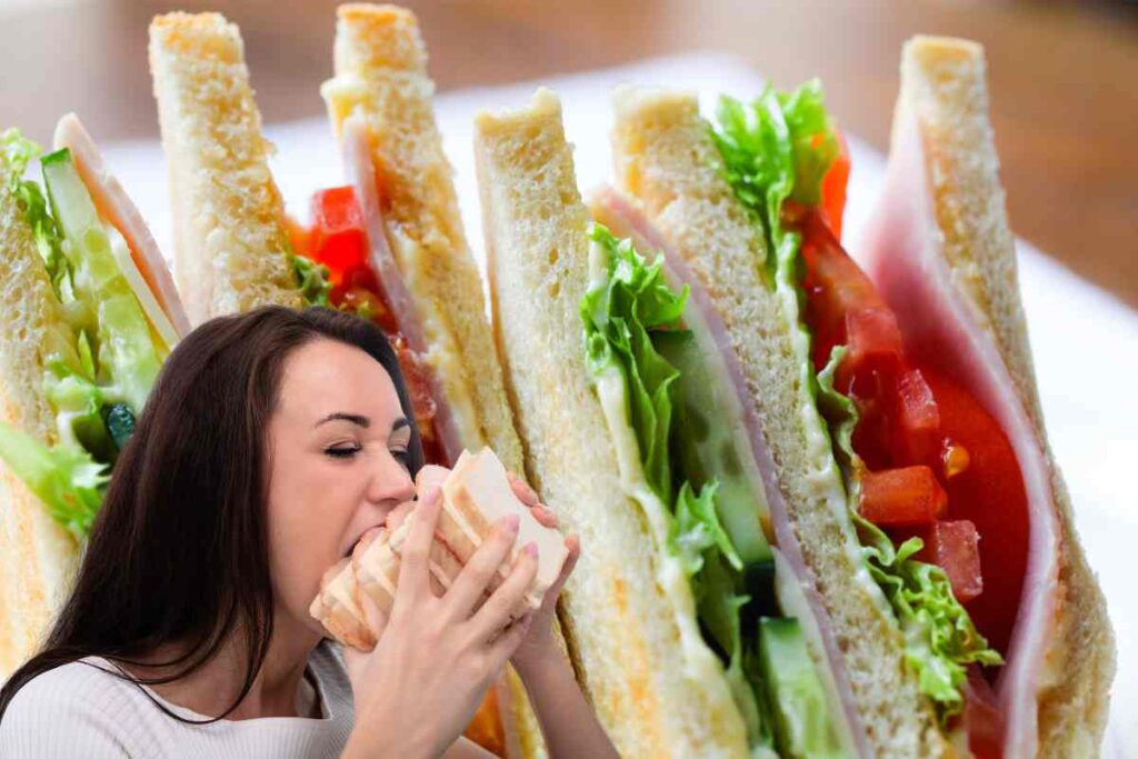 Dei sandwich freschi ed una donna che mangia