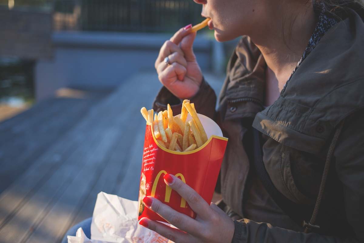 ragazza che mangia patatine fritte