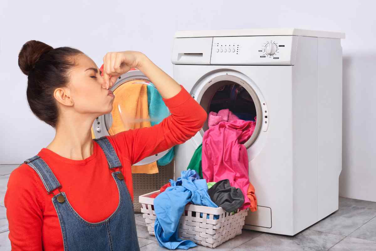 Bucato finito ed una donna che non sopporta la puzza dalla lavatrice