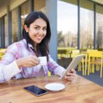 donna con il caffè e il cellulare