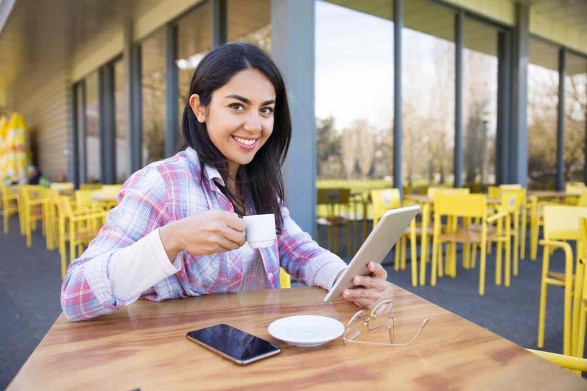 donna con il caffè e il cellulare